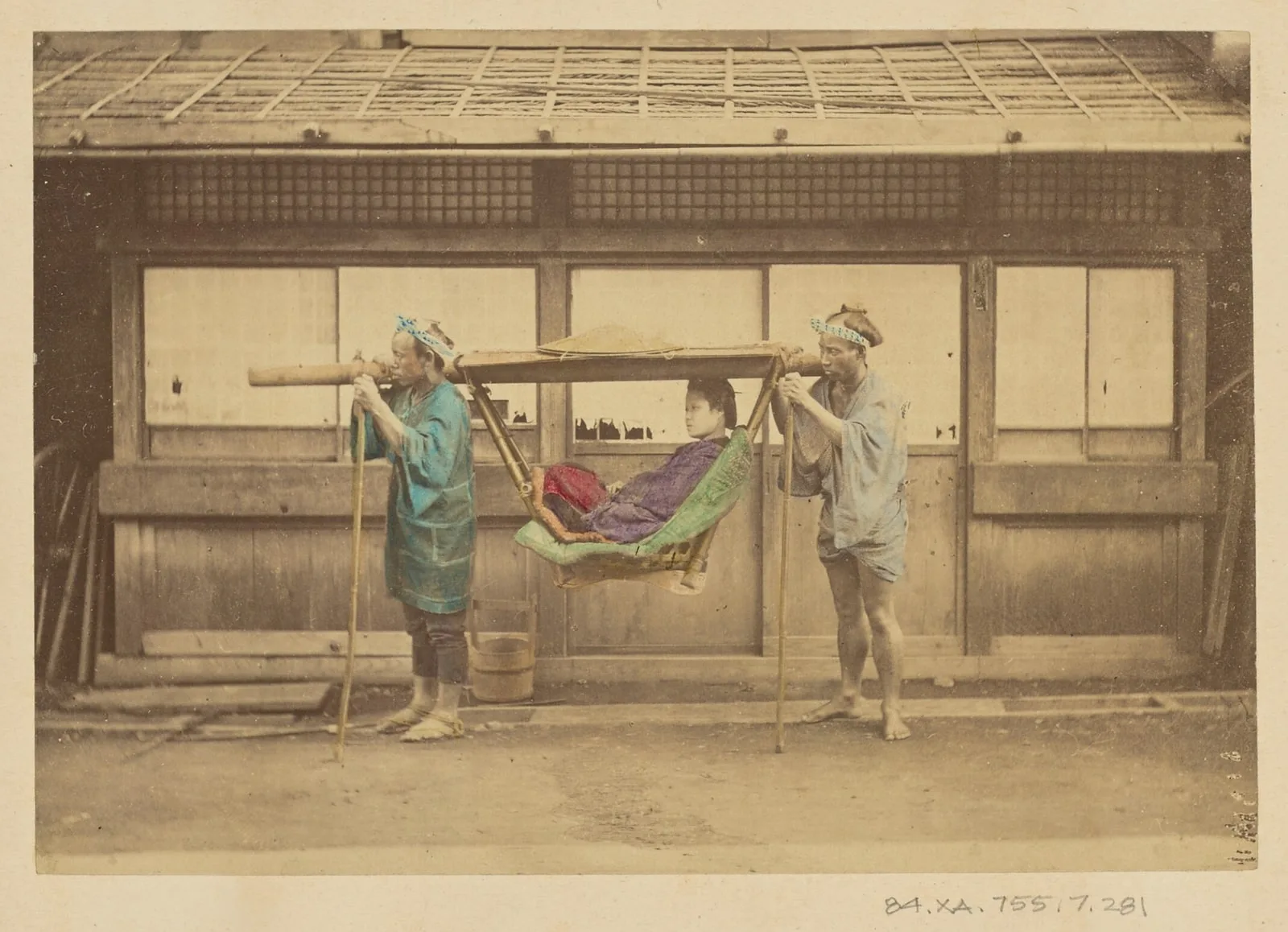 [Japanese woman being carried by two Japanese men in a kago]