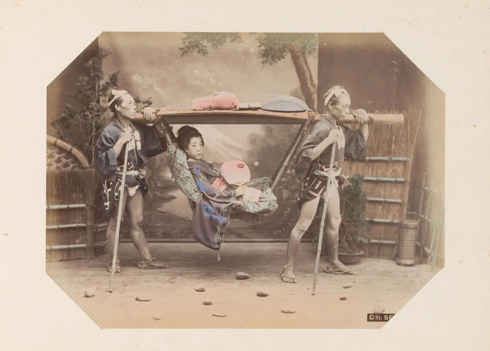 Japanse vrouw in een draagstoel met twee dragers